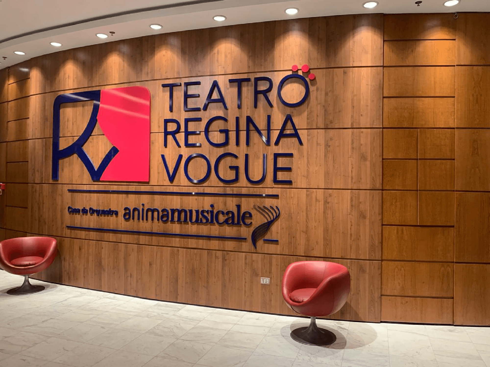 Painel de madeira do foyer do Teatro Regina Vogue com a nova marca aplicada